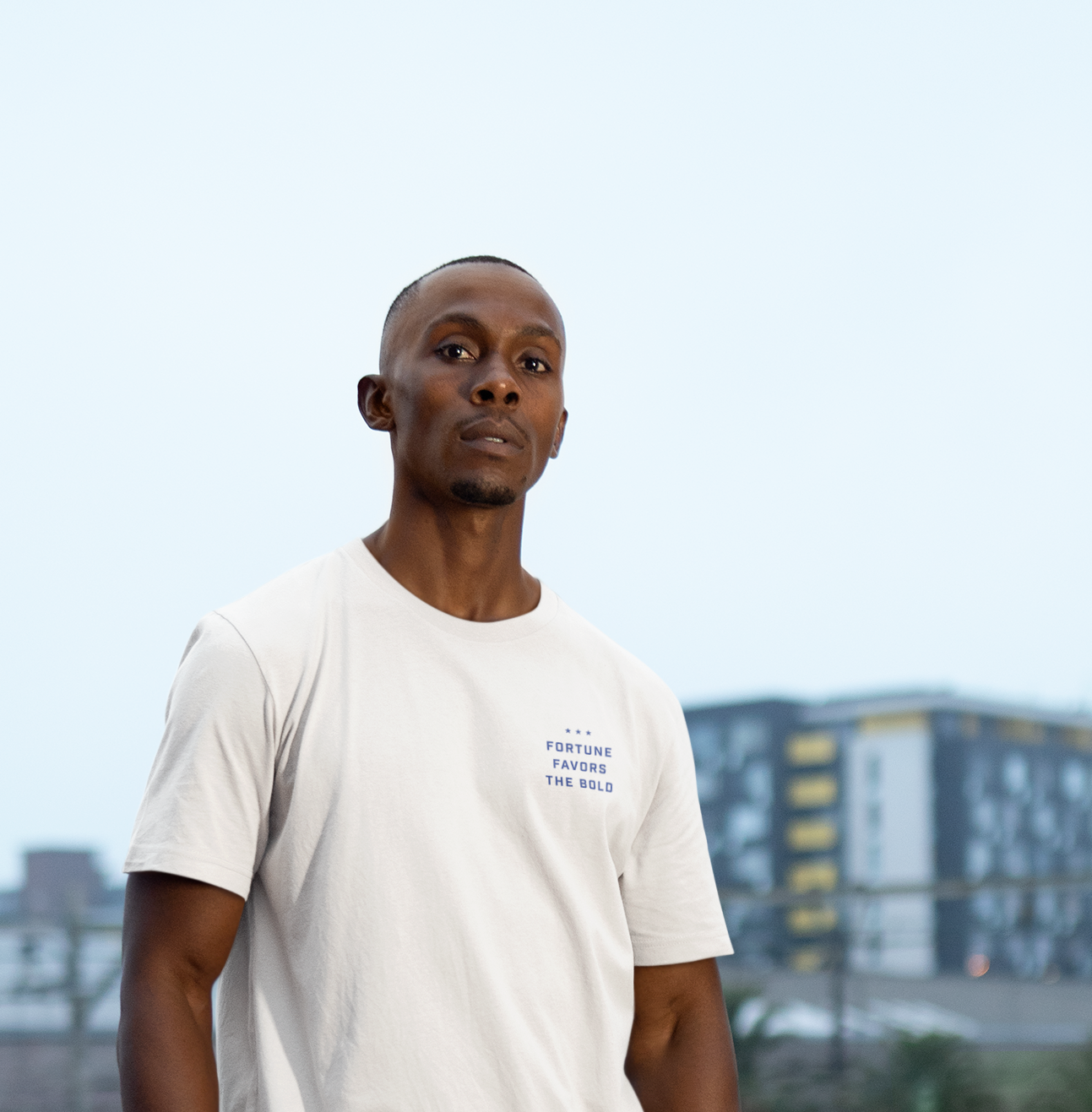 Man wearing a white t shirt with the words fortune favors the bold on the chest.