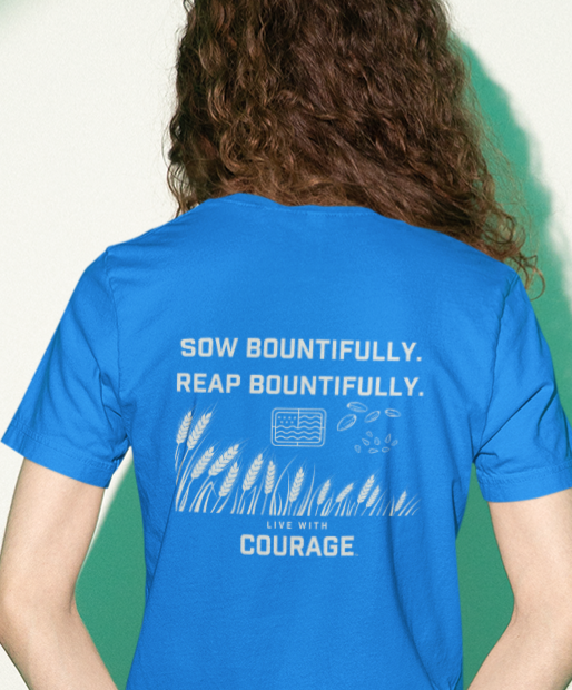 A woman wearing a blue crew neck t-shirt with the text 'SOW BOUNTIFULLY. REAP BOUNTIFULLY.
