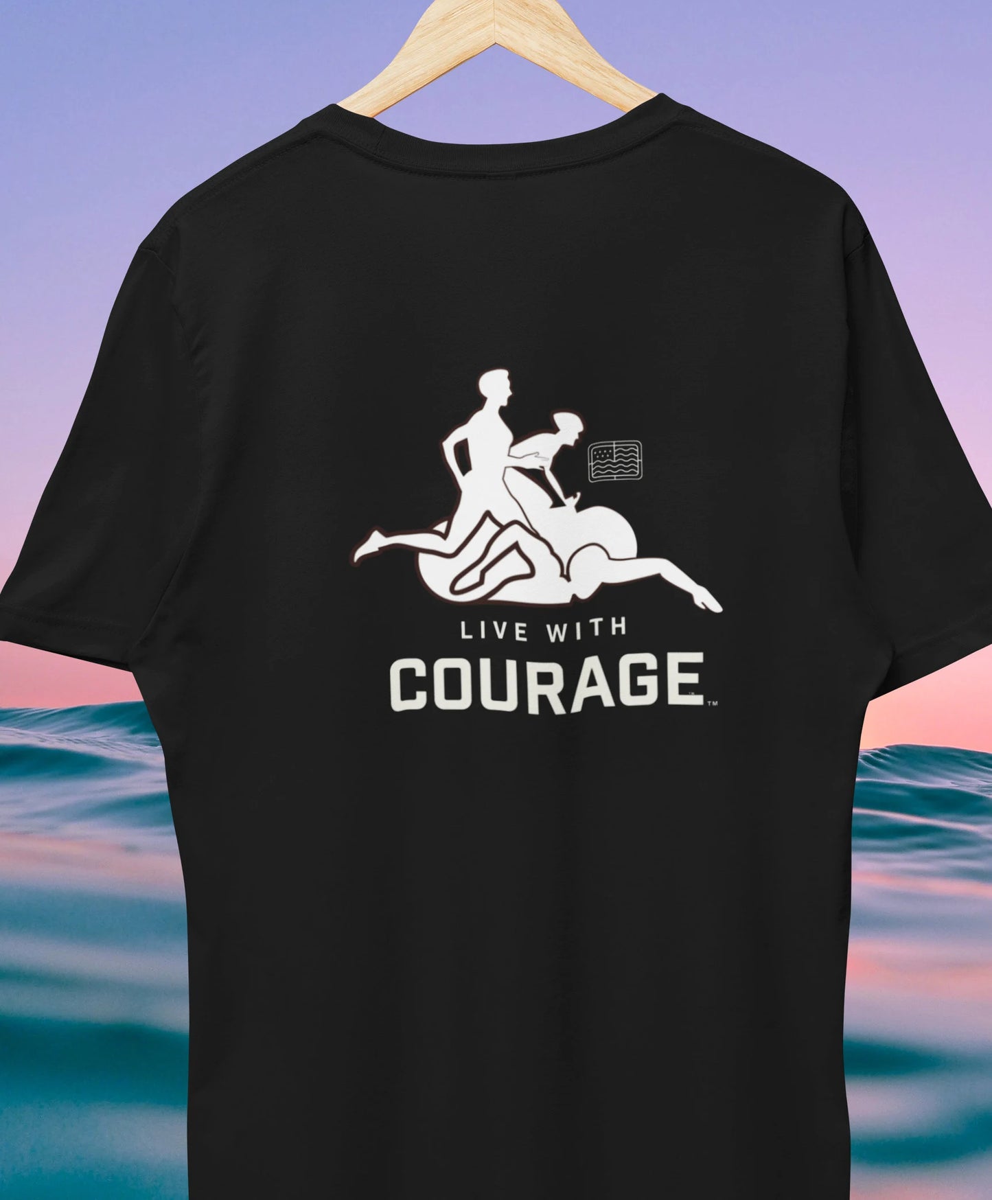A black unisex short-sleeve t-shirt with a graphic print of a person swimming, running and biking and the text 'LIVE WITH COURAGE' on the back.